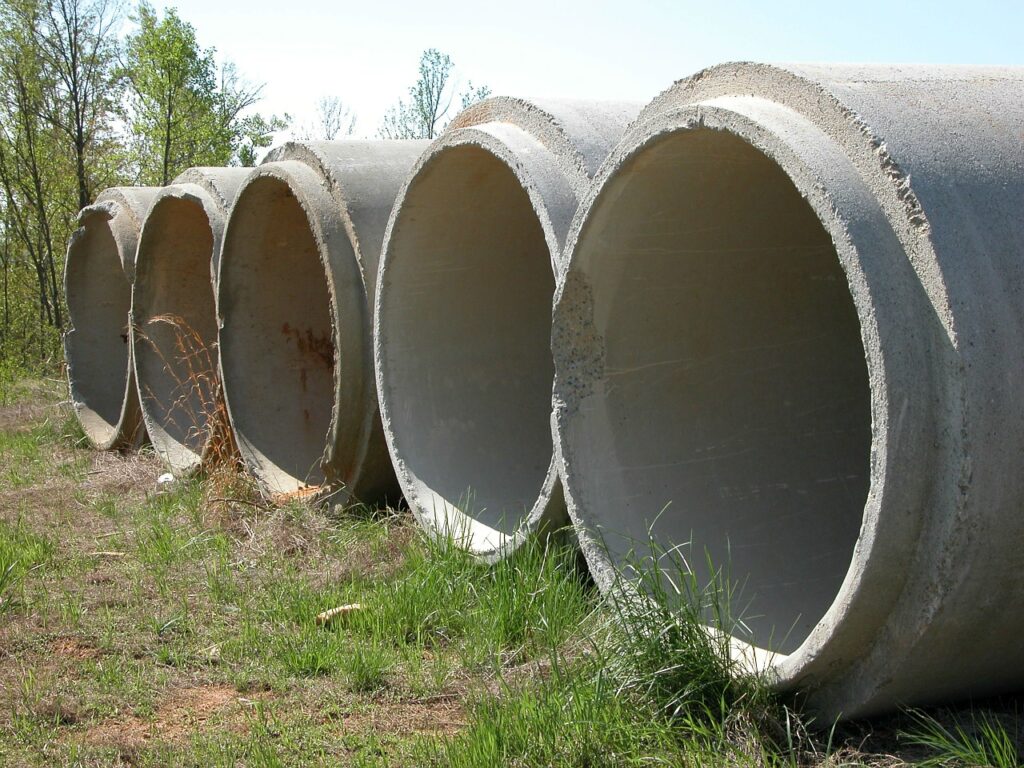 five large cement pipes on grass