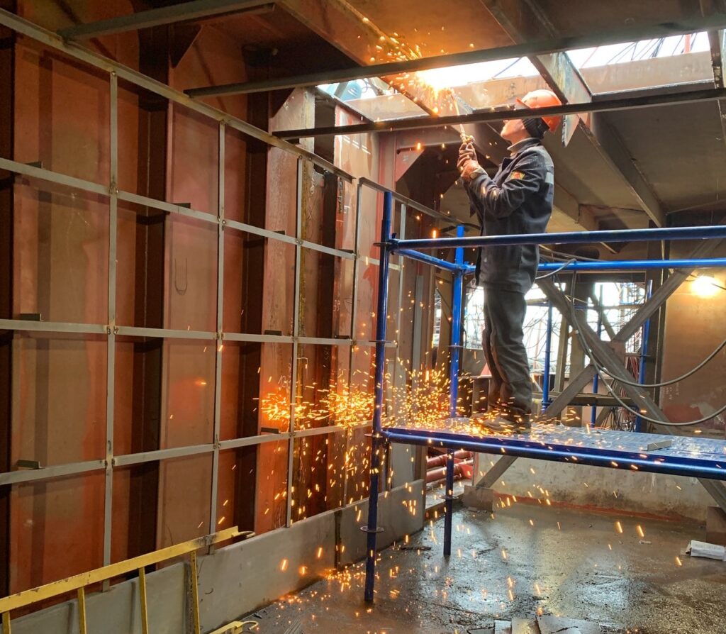 Man welding beam in new construction