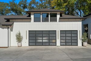 Modern single-family home with two glass-panel garage doors and a concrete driveway